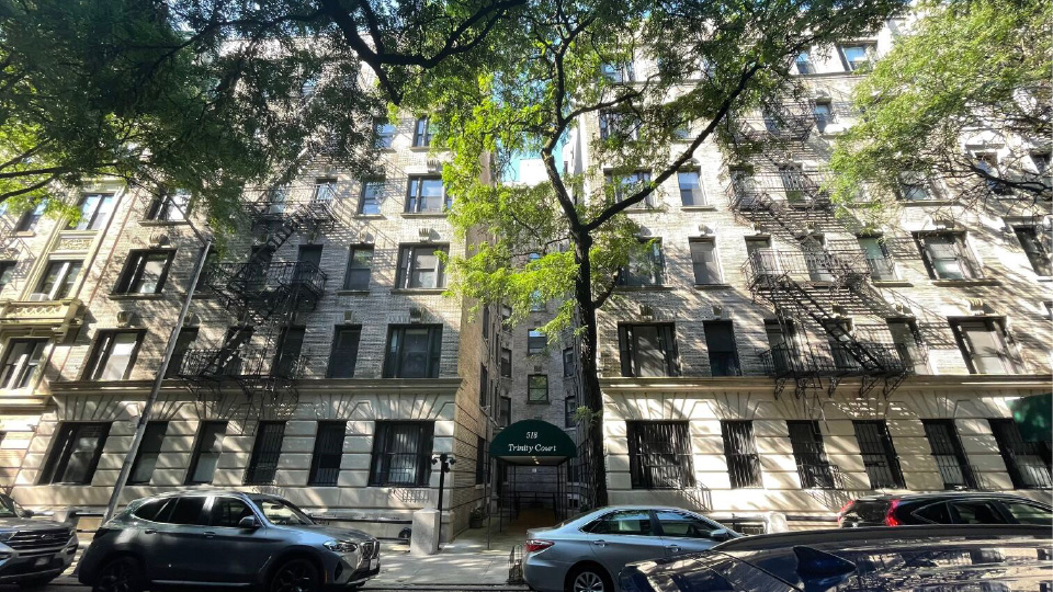 The exterior of 611 W. 112th Street, a white brick apartment building.