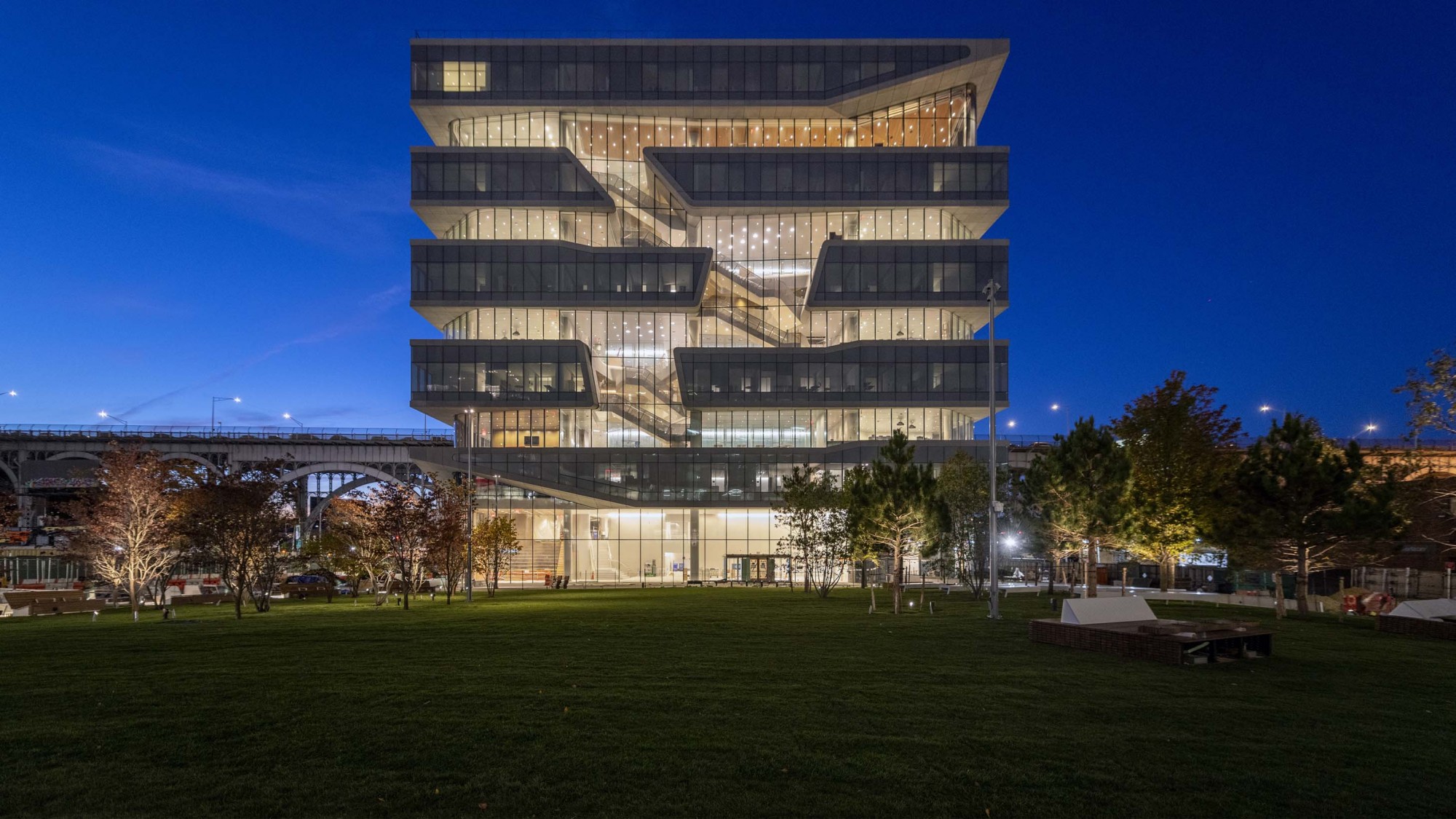 A photo of the new Columbia Business School during the evening with the lights turned on in the building