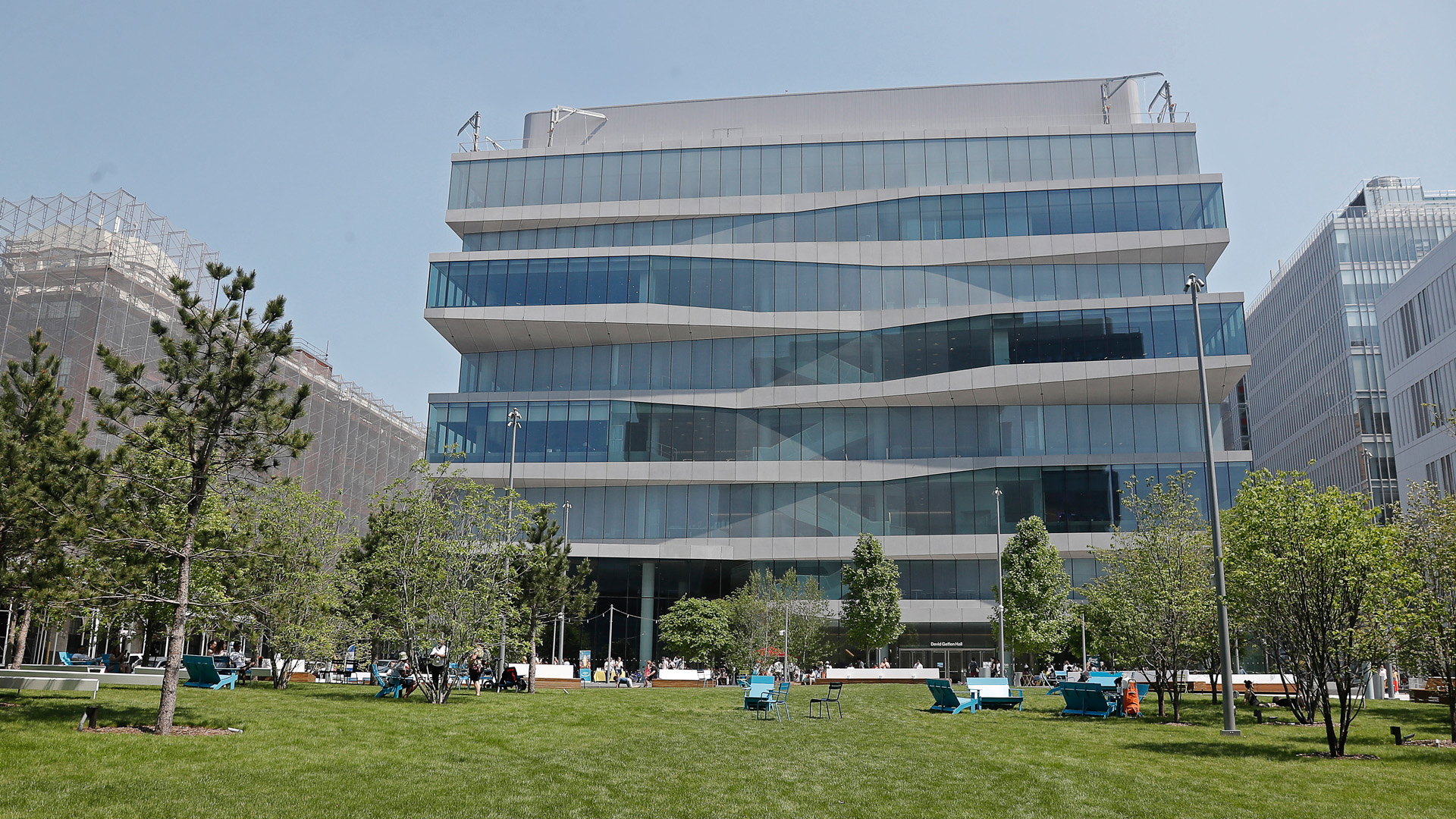 A view of The Square, a grassy green space with lawn chairs out, in front of David Geffen Hall.