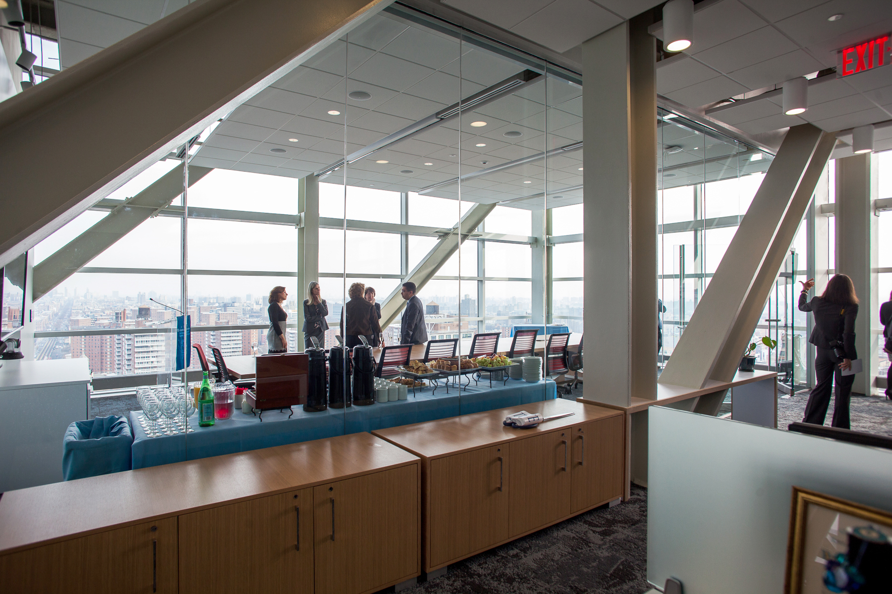 A view of the Northwest Corner Beacon conference room with people gathering around by the windows.