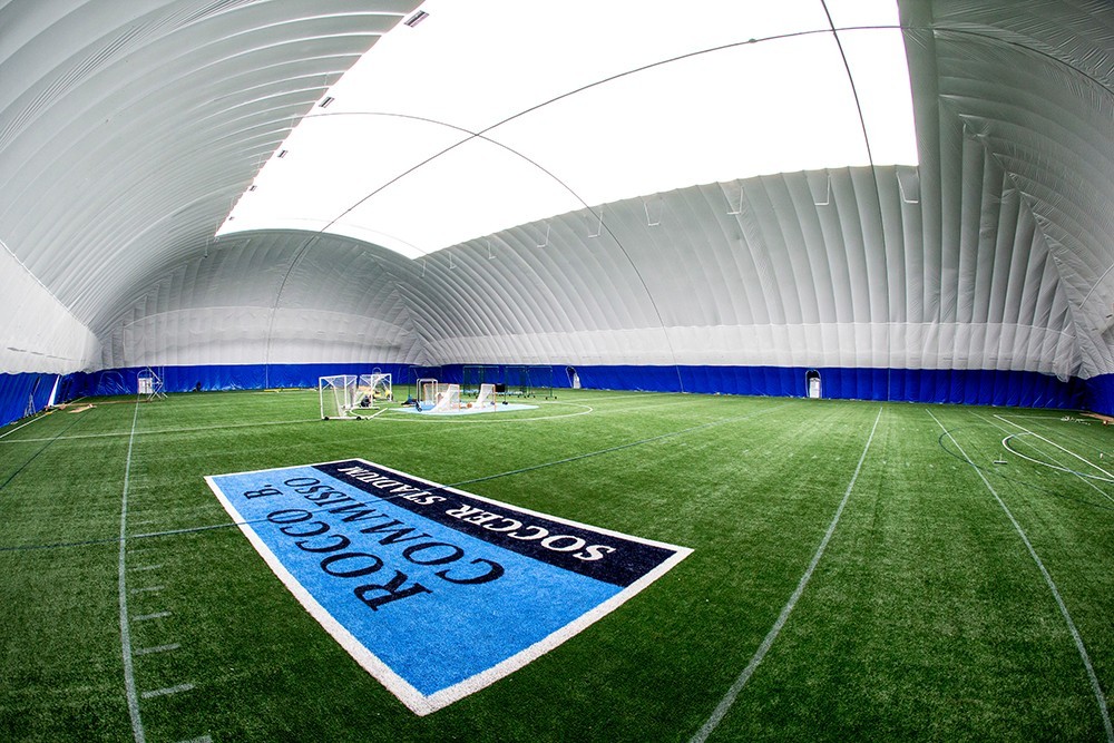 Interior shot of the seasonal air supported structure at the Baker Athletics Complex. There is a turf field underneath an inflated white and blue walled structure.