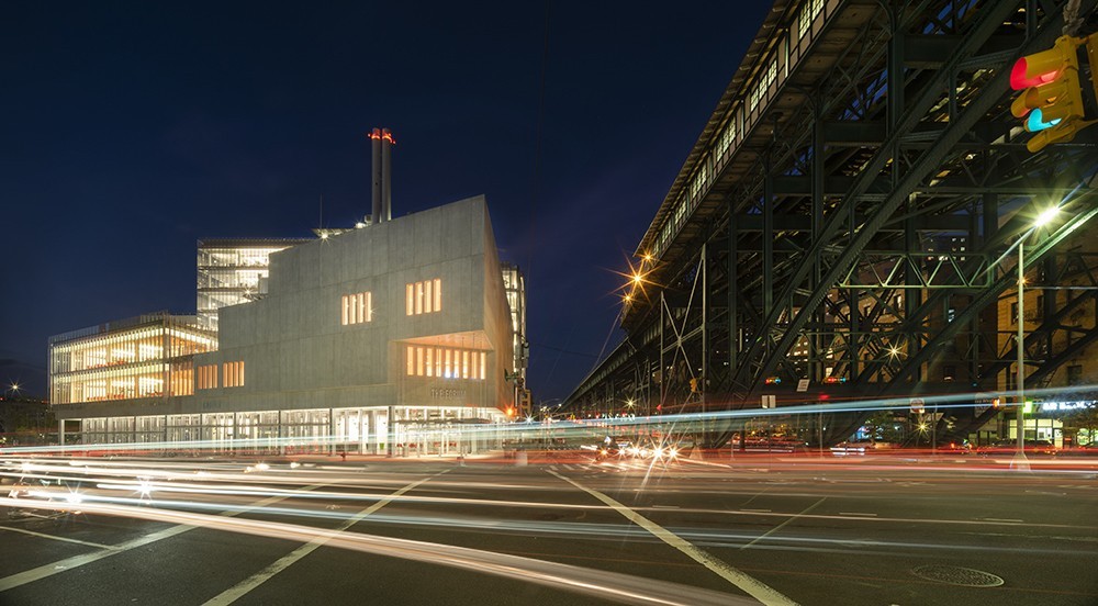 The Forum building, a wedge-shaped concrete structure, at night. 