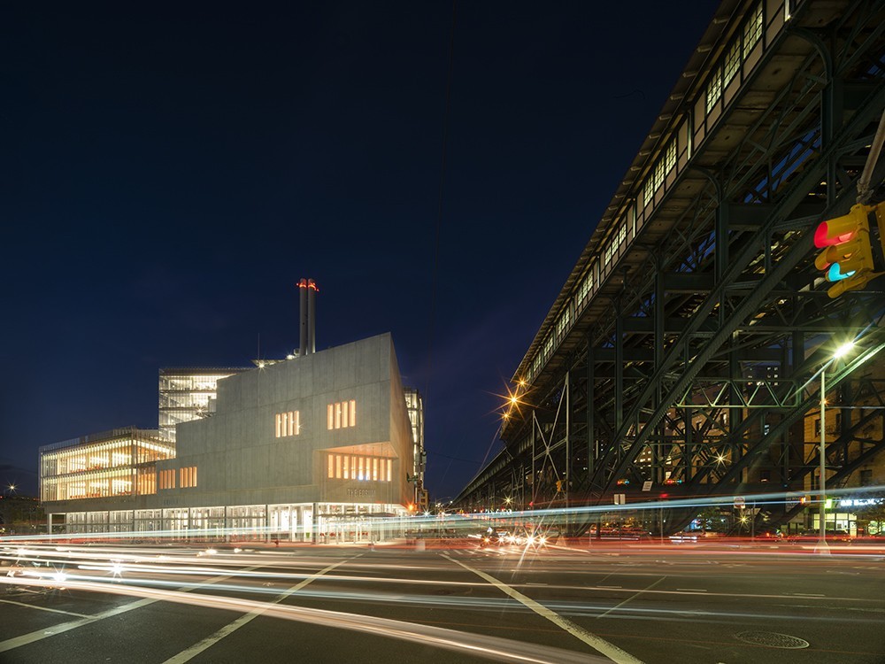 The Forum building, a wedge-shaped concrete structure, at night. 