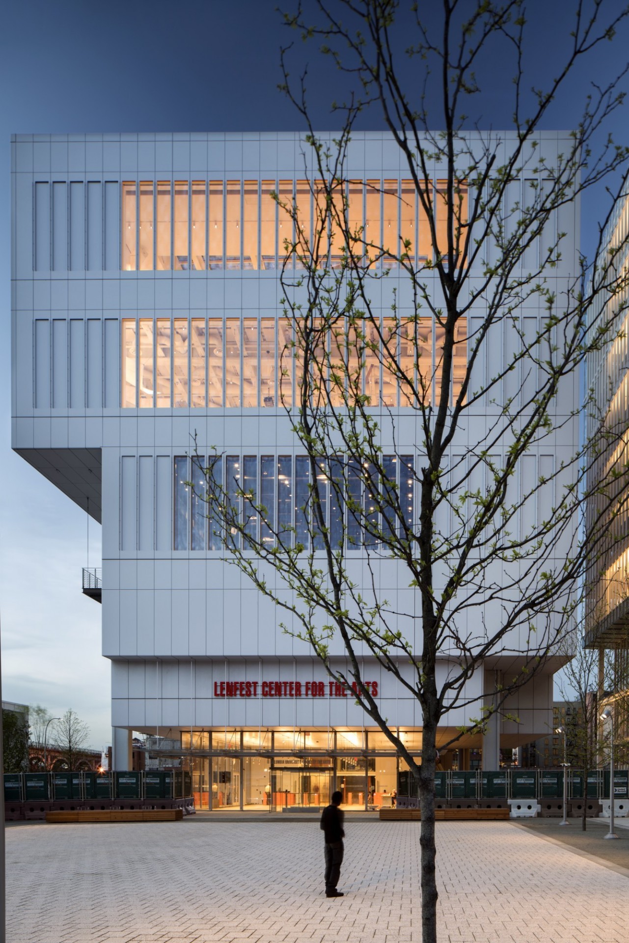 Exterior shot of Lenfest Center for the Arts, a concrete and glass structure. A tree with budding leaves partially obscures the view of the building.