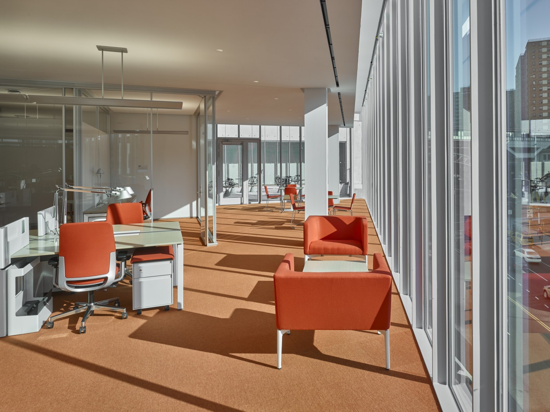 An open work space with desks, tables and lounge chairs.