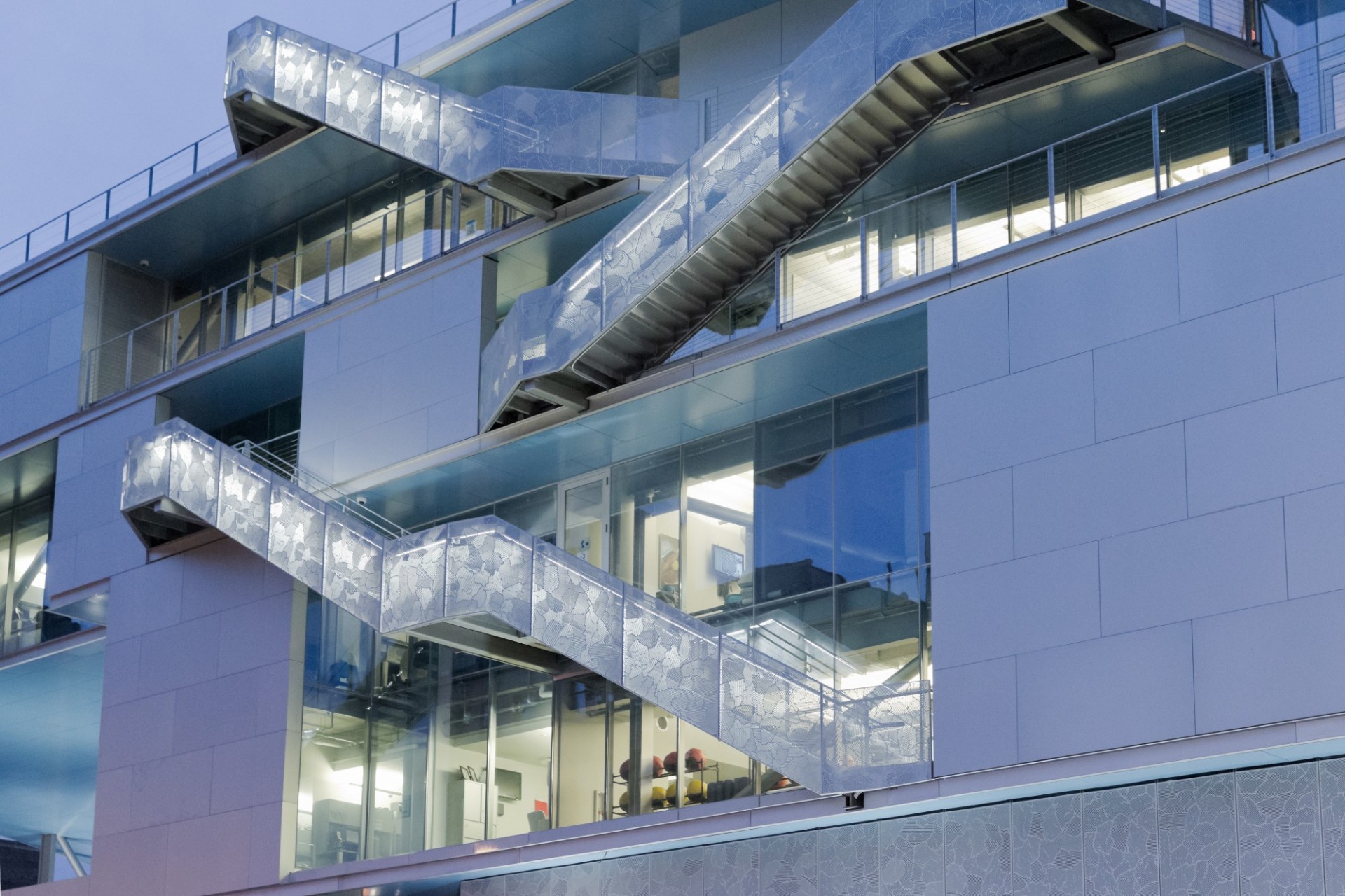 A close up of the exterior staircases of Campbell Sports Center taken at dusk.