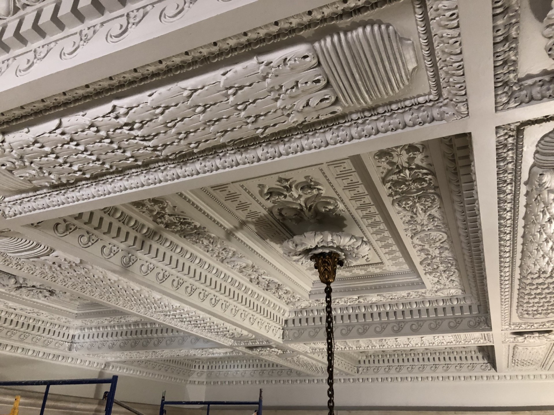 A wide view of the completed repairs and restoration to the ornate plaster ceiling.