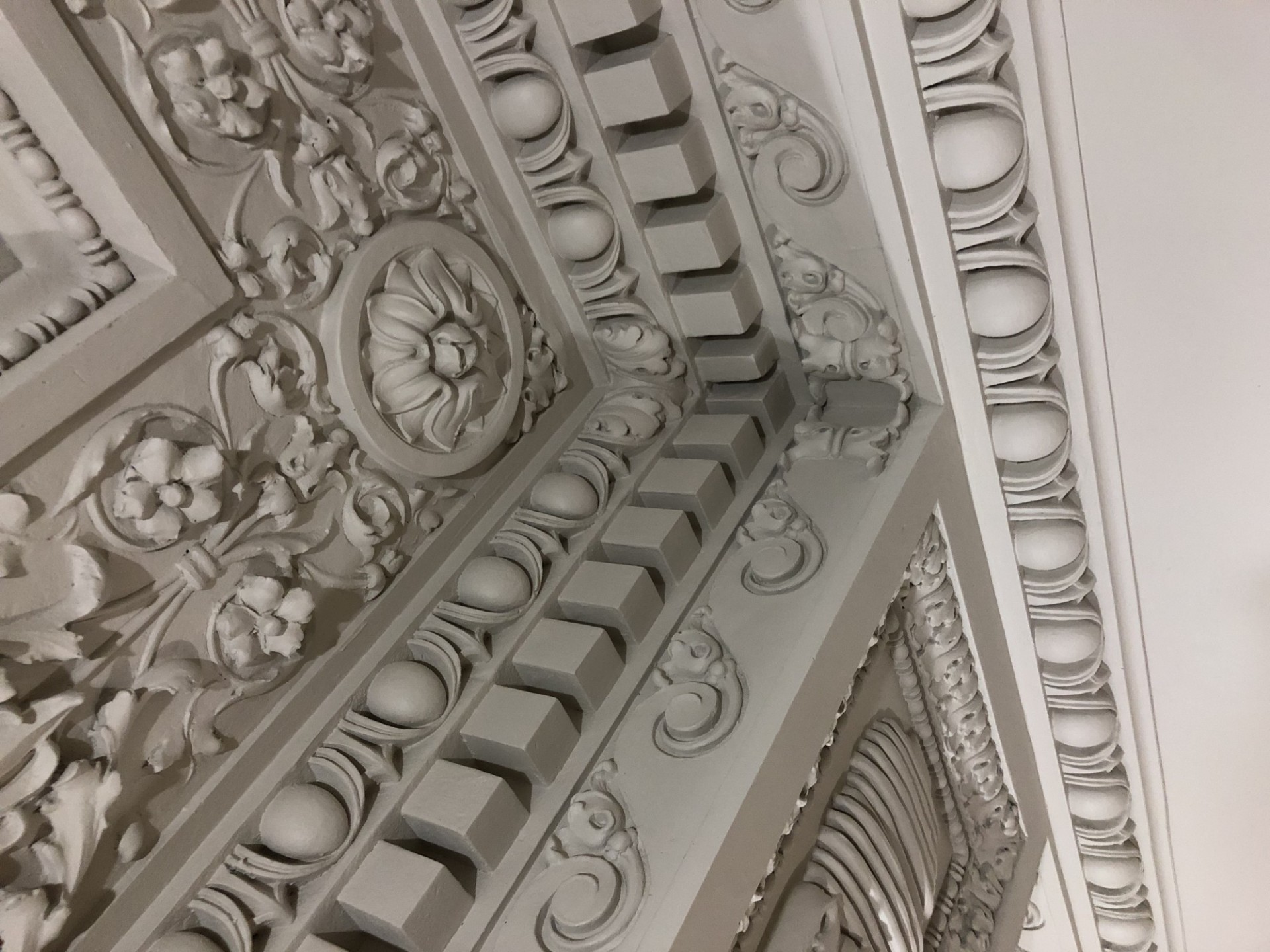 A close-up view of a section of the repaired and restored ornate plaster ceiling.