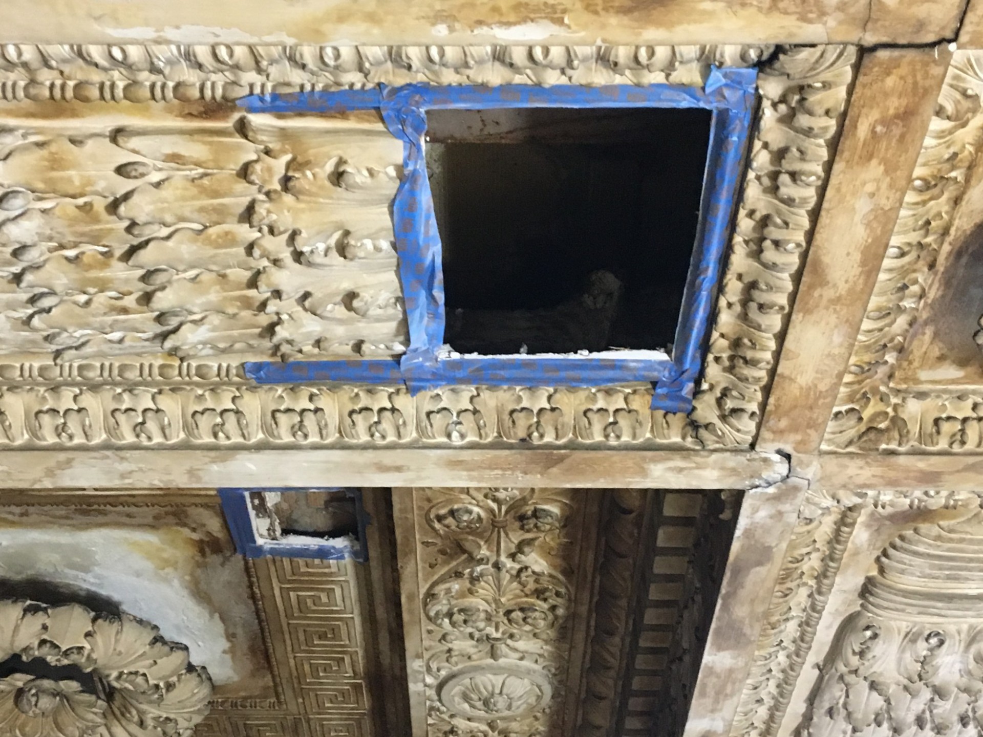 A rectangular section has from the ornate plaster ceiling has been removed. 