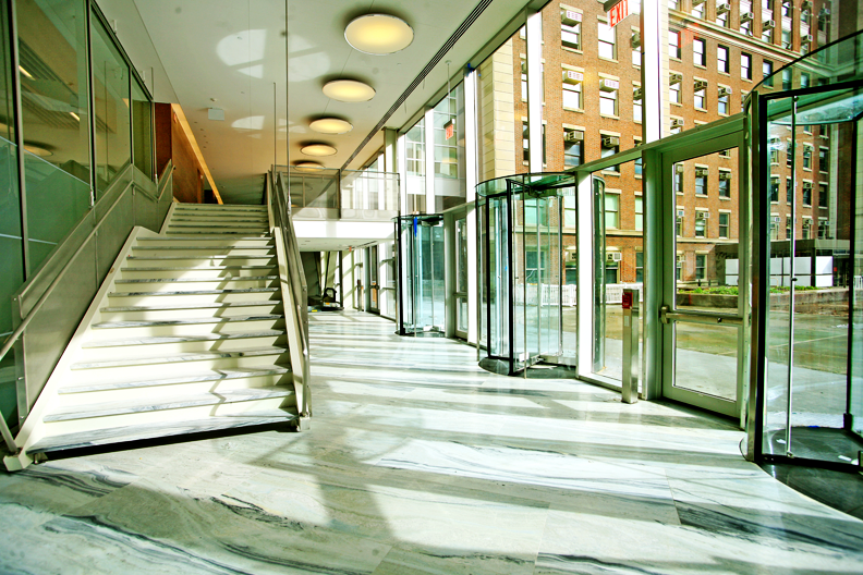 Northwest Corner Building interior, campus-level lobby, glass revolving doors leading to marble-tiled lobby and staircase