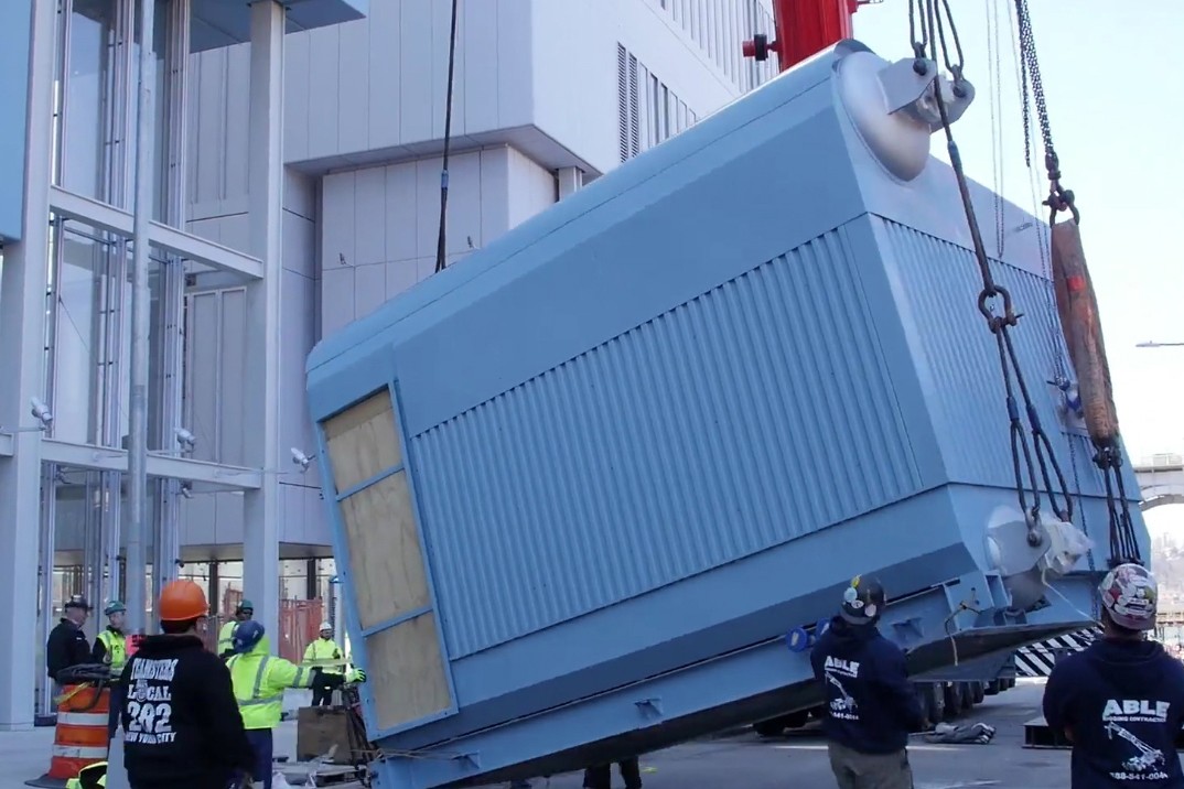 Installation of a large boiler inside of a hatch next to the Jerome L. Greene Science.