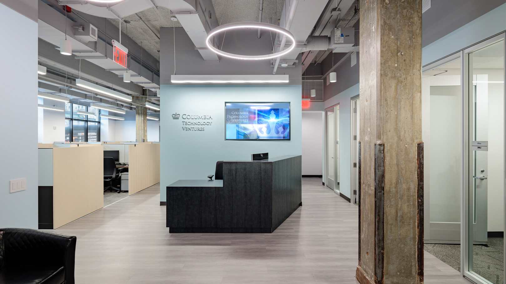 Newly renovated office suites in the Nash Building for Columbia Technology Ventures, which has Columbia blue painted walls, and light brown cubicles.
