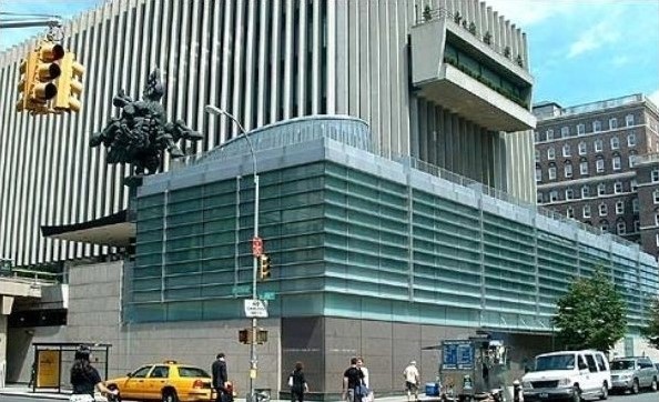 A tall, concrete structure with a glass extension. 