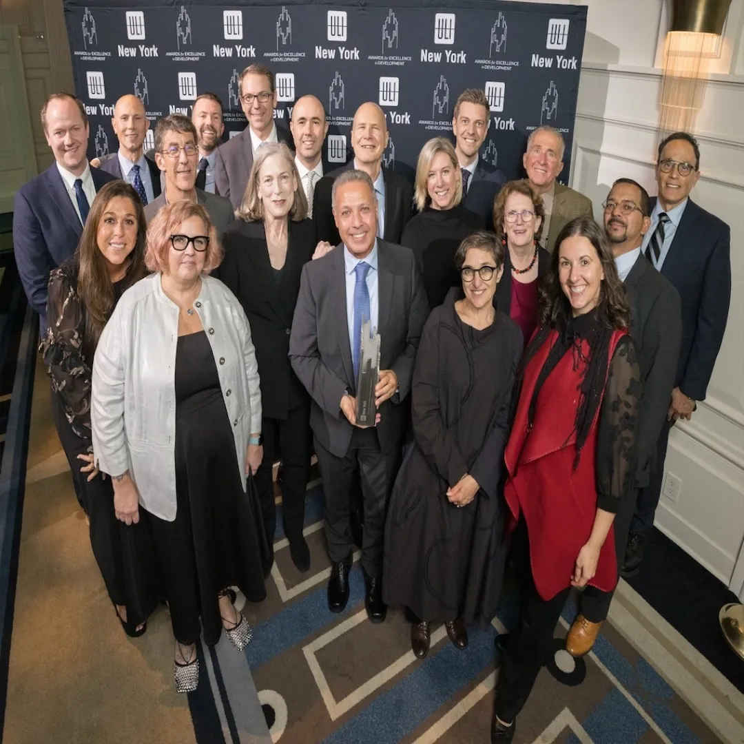 The Manhattanville Development Group gathers with other members of the project team, holding an award.