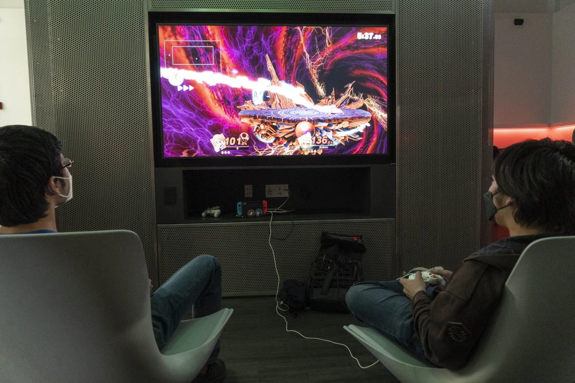 Two students playing a video game on one of the large screens.