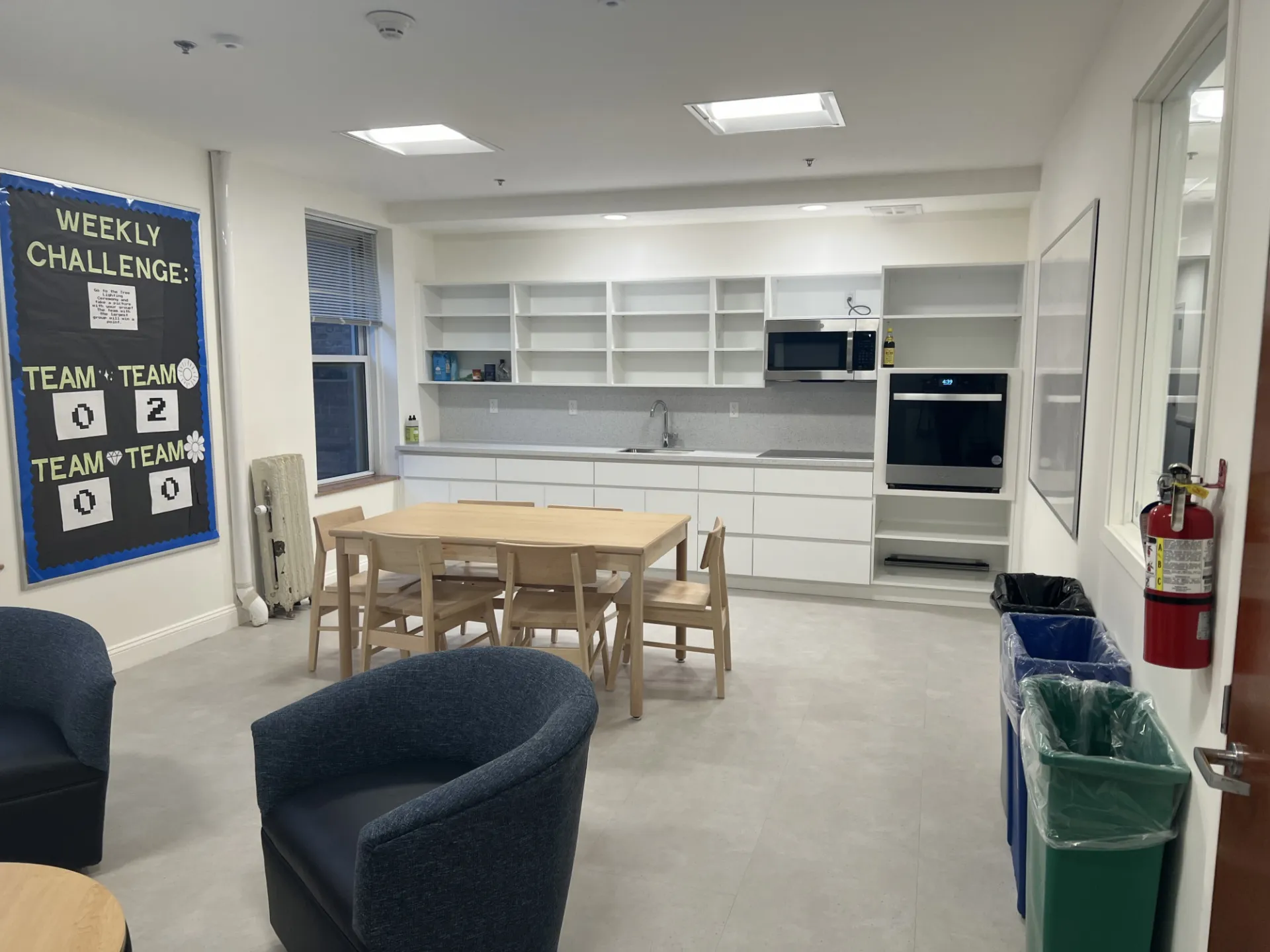 A refreshed kitchen lounge in McBain Hall that has new white kitchen cabinetry, appliances, and furniture.