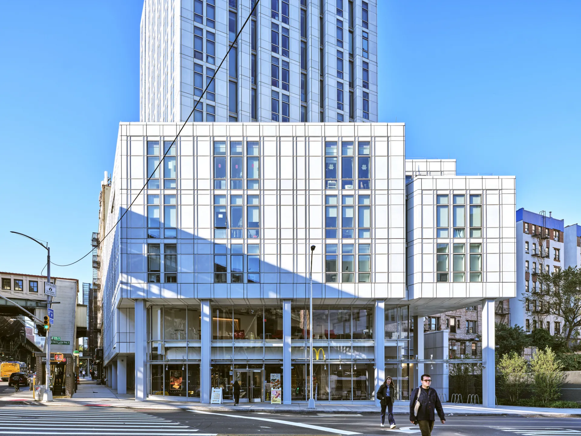 A view of the lower floors of 600 W. 125th Street, a 34 story residential building with a light gray, high performance facade.