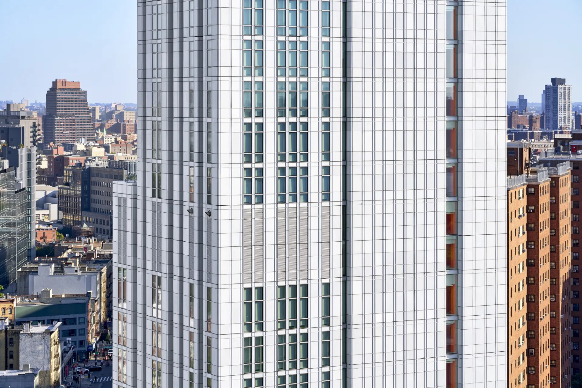 A view of the higher floors of 600 W. 125th Street, a residential building with a light gray high performance facade.