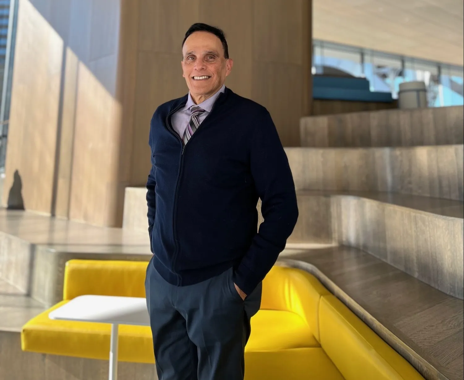 Jim Sugaste stands smiling in the Commons of Columbia Business School.