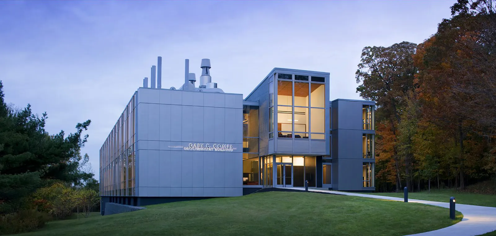The Gary C. Comer Building, a concrete and glass structure, at dusk.
