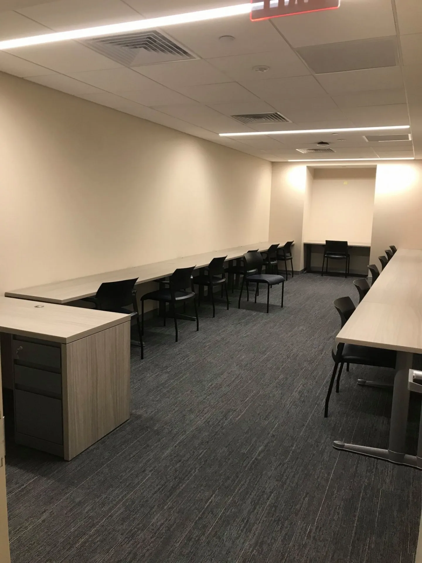 Long tables with black chairs facing the walls of the room