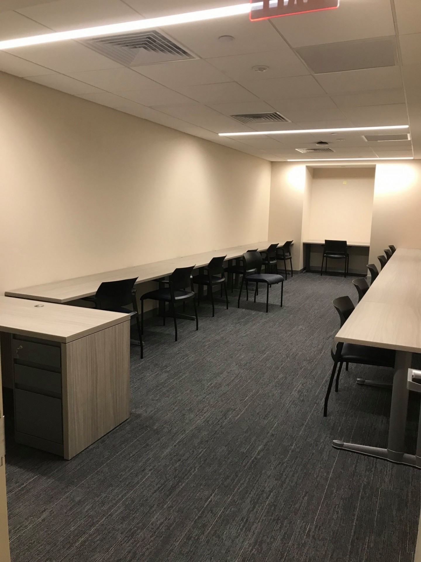 Long tables with black chairs facing the walls of the room