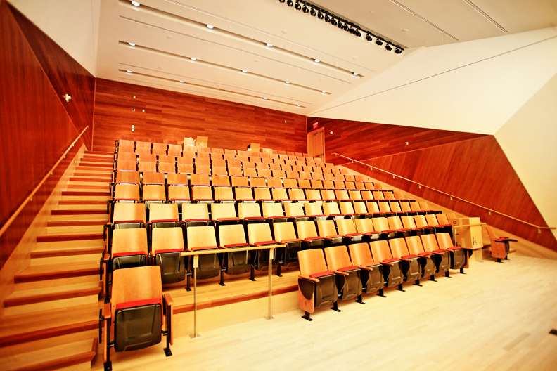 Fifth floor lecture hall seats over 100 people Northwest Corner Building interior, wood-paneled fifth floor lecture hall room with more than 100 wooden seats
