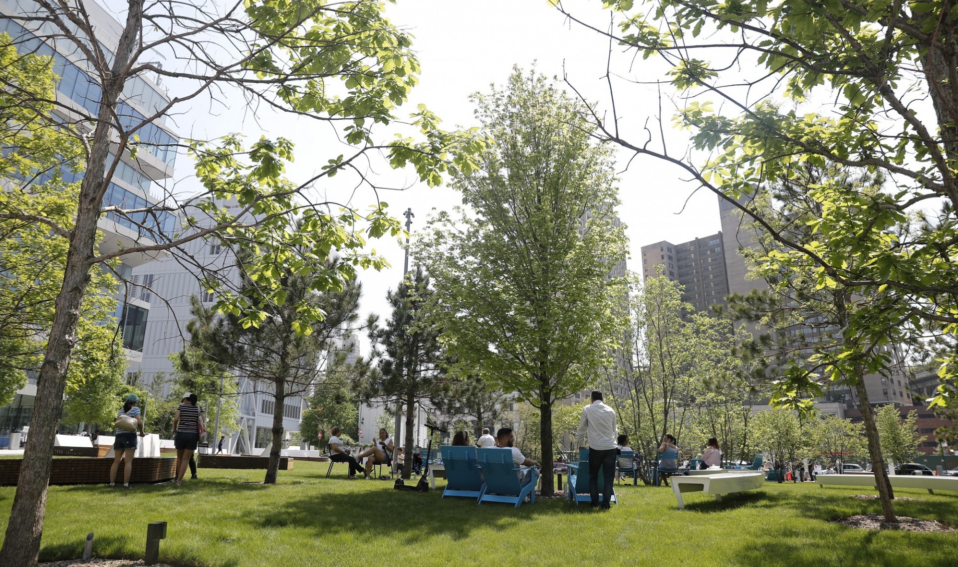 People gather at The Square and lounge in chairs set up on the grass.